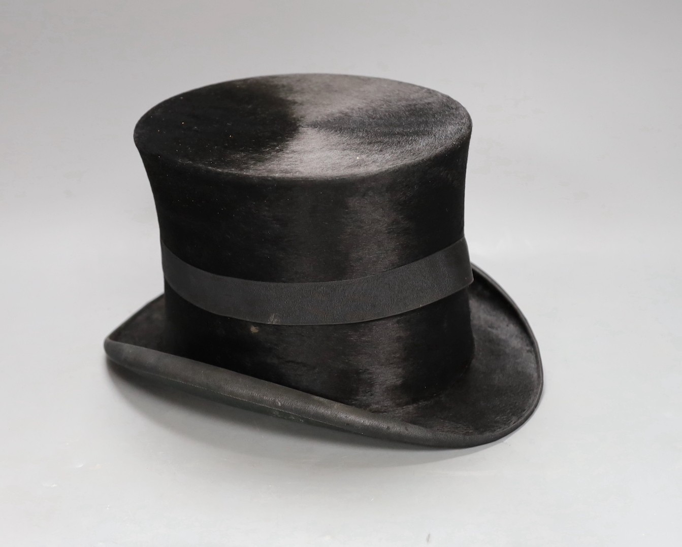 A leather cased Cuthbertson top hat, 19.5x15.5cm